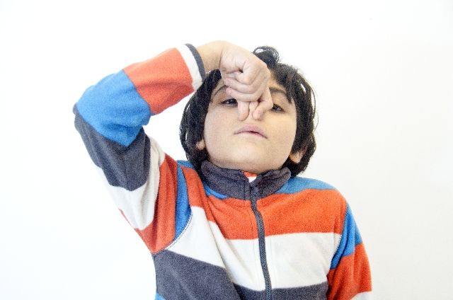 鼻をつまむ少年